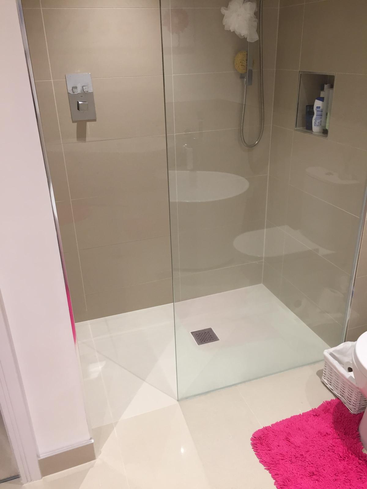Compact walk-in shower with low-profile stone resin tray, frameless glass screen, recessed niche and concealed thermostatic valve.